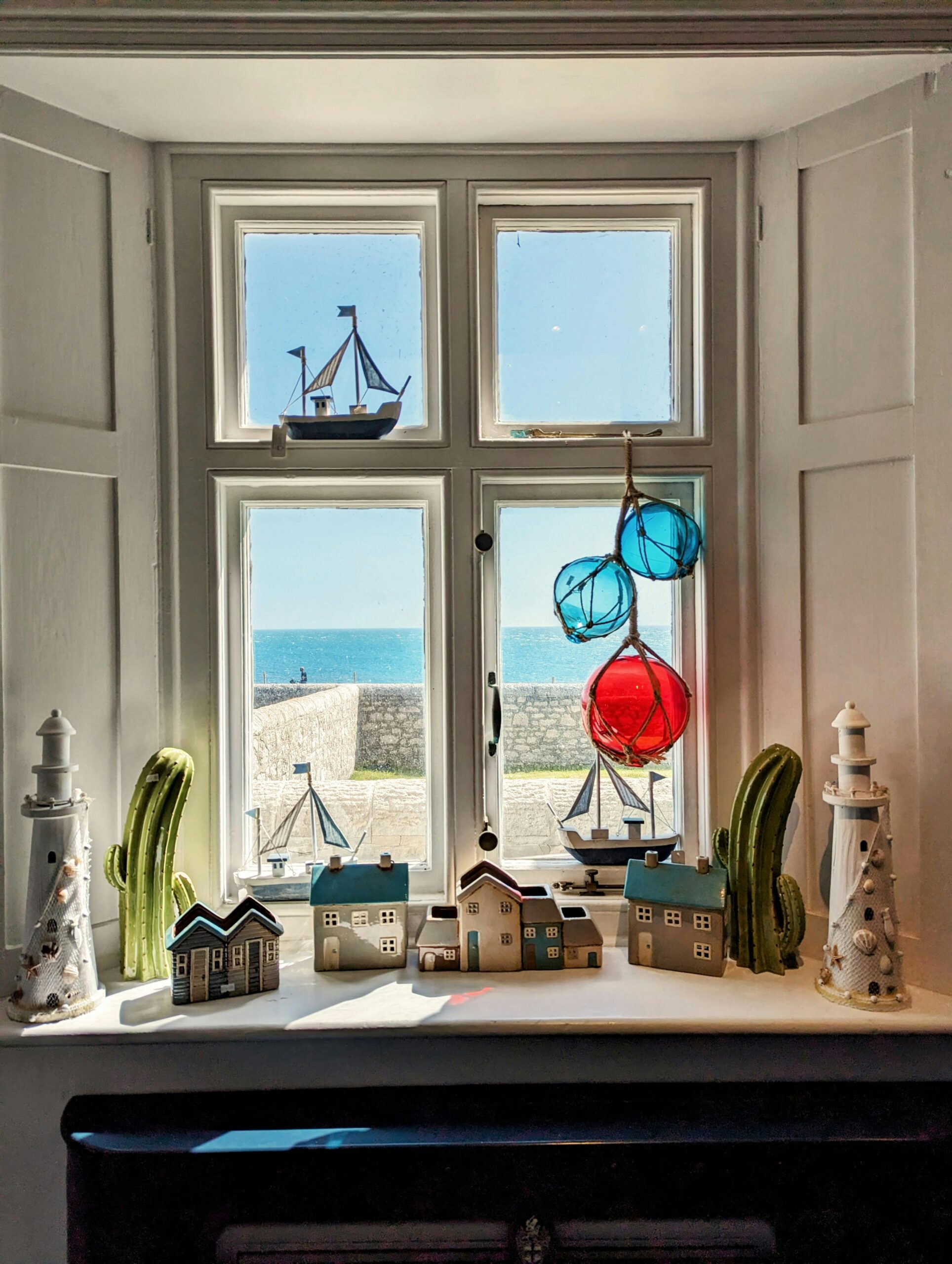 A view of a home by the ocean with decorations around the window.